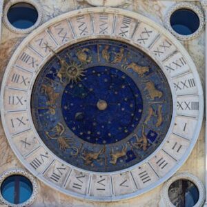 A detailed view of the historic astrological clock in Venice, featuring zodiac signs and Roman numerals.
